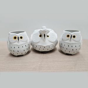 Small owl-shaped teapot and two owl-shaped teacups, white with white bellies.