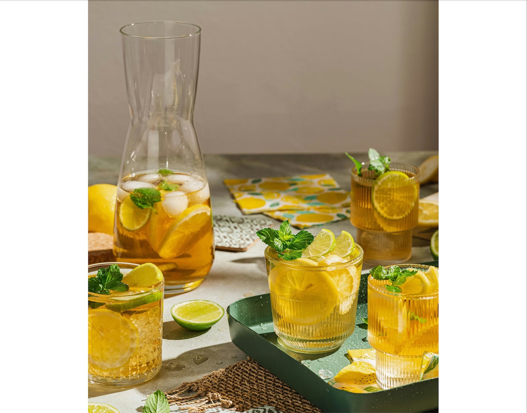 iced tea in a pitcher and glasses with lemon and mint